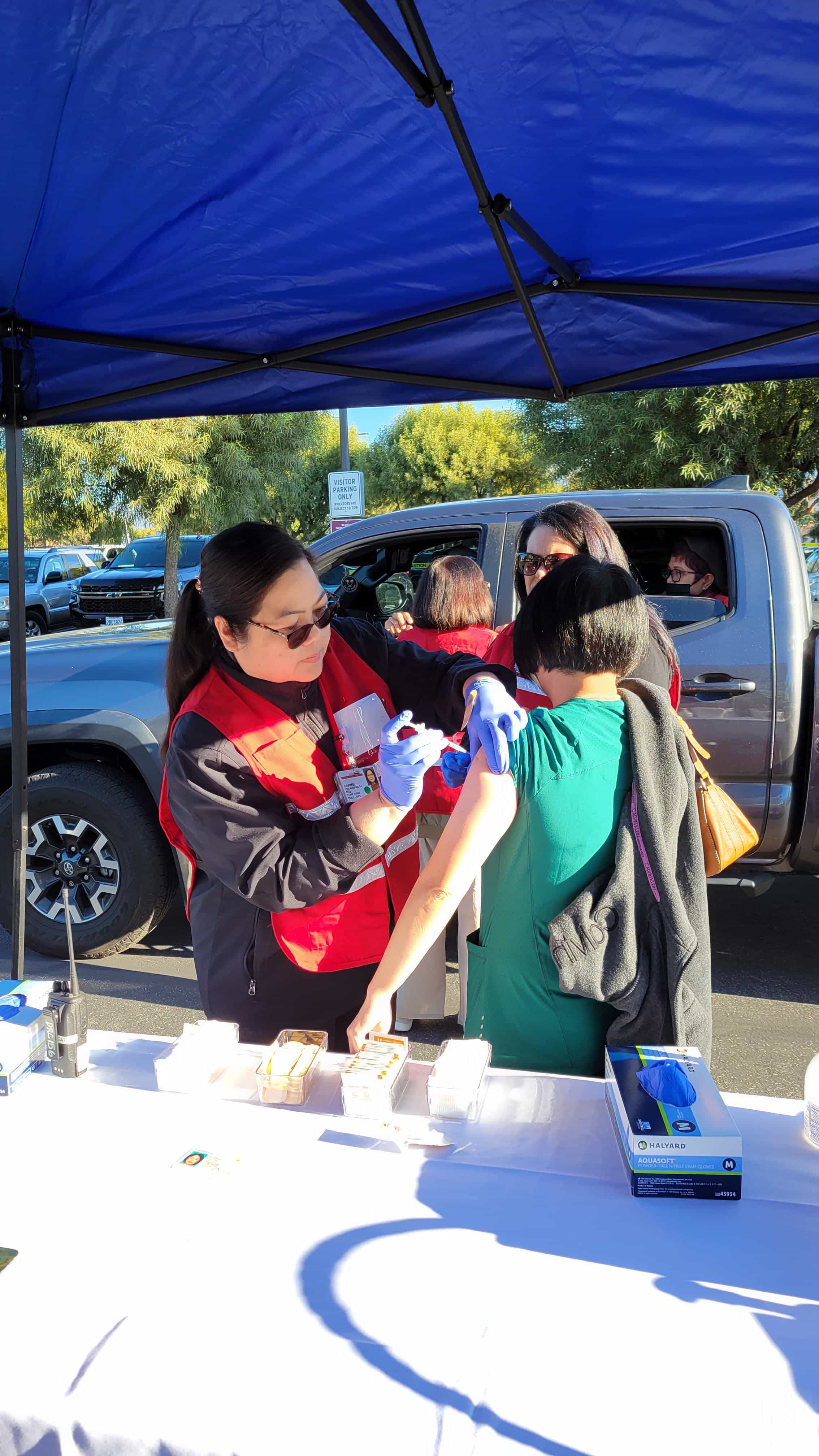 Woman giving a vaccine to a child